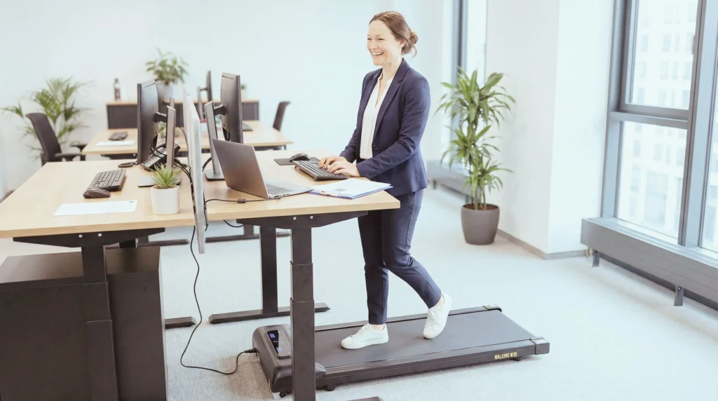 En kvinna går på Titan Life Walking Pad W10 vid skrivbordet på kontoret