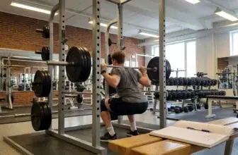 en man på gymmet som val korrekt vikt på skivstången för knäböj